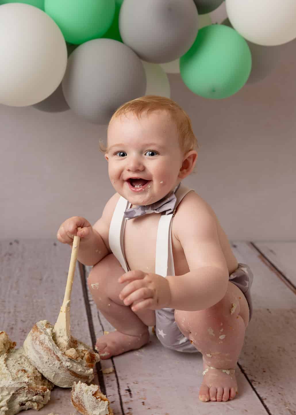 little boy in shorts and tie with smashed cake ipswich photographer