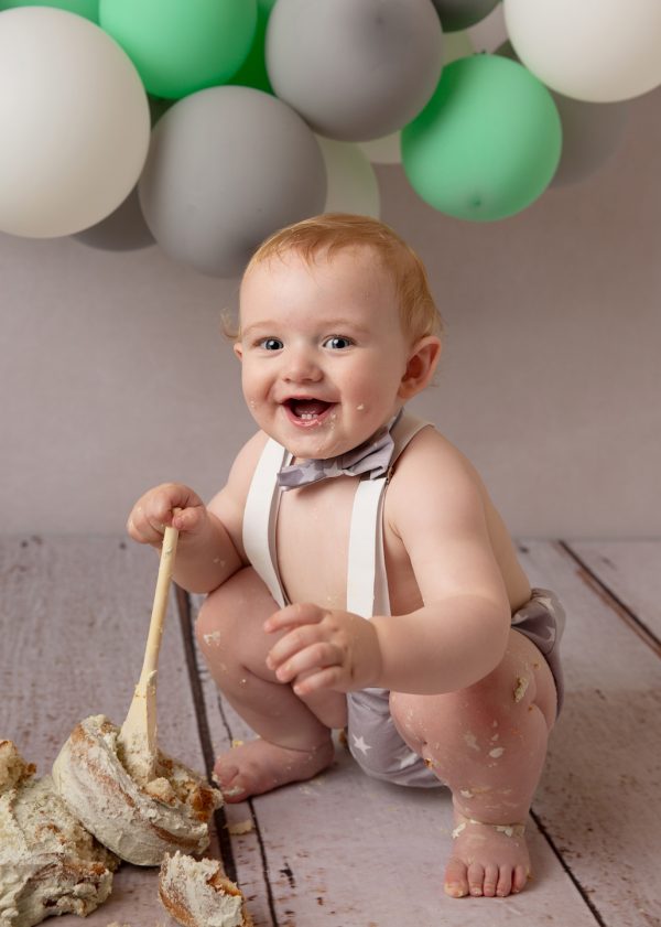 newborn and family photographer ipswich cake smash laughing boy with spoon