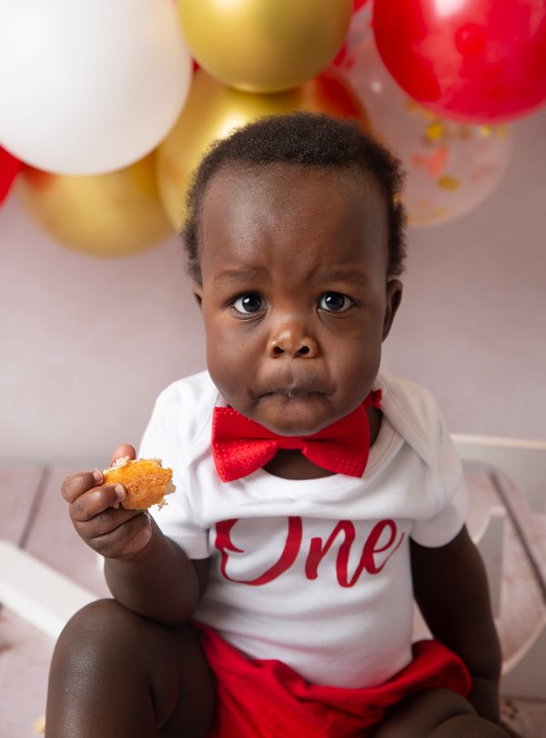 cake smash photographer ipswich boy eating cake red and gold setup