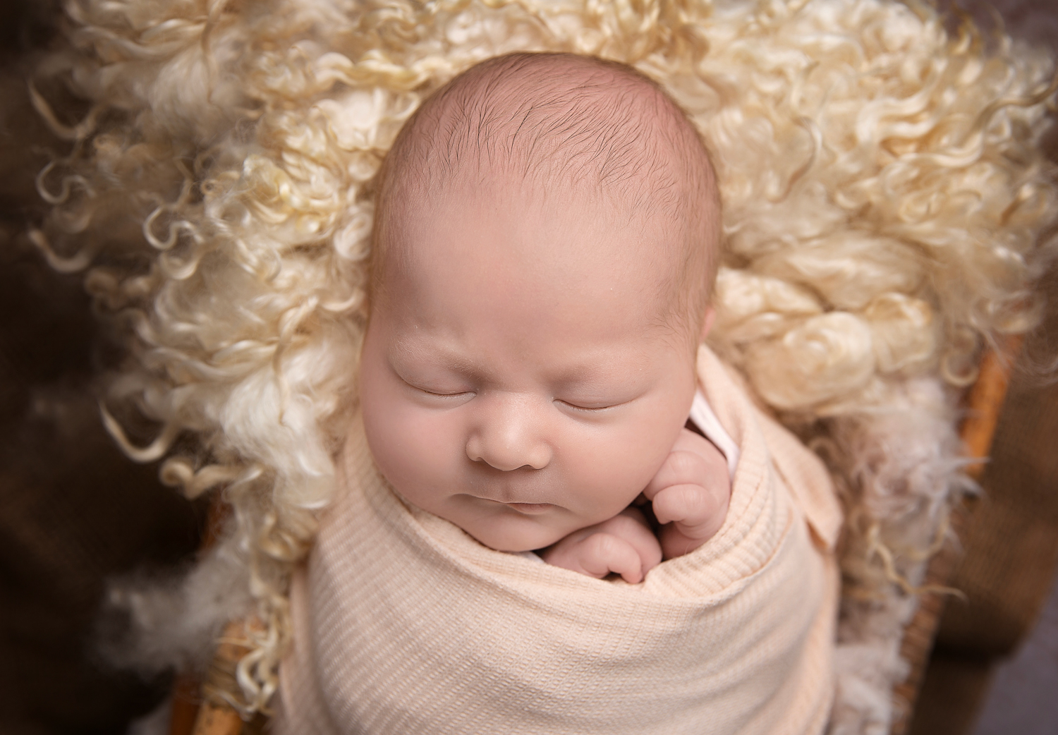 newborn and family photographer ipswich baby with cream fur and blanket