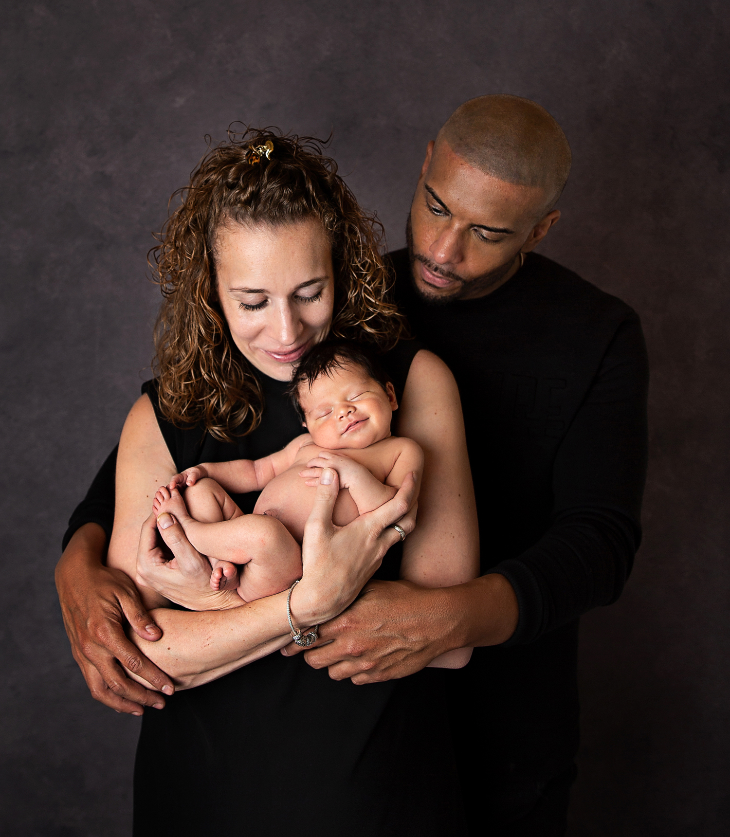 newborn and family photographer ipswich baby smiling held in mums arms with dad newborn and family photographer ipswich baby smiling held in mums arms with dad