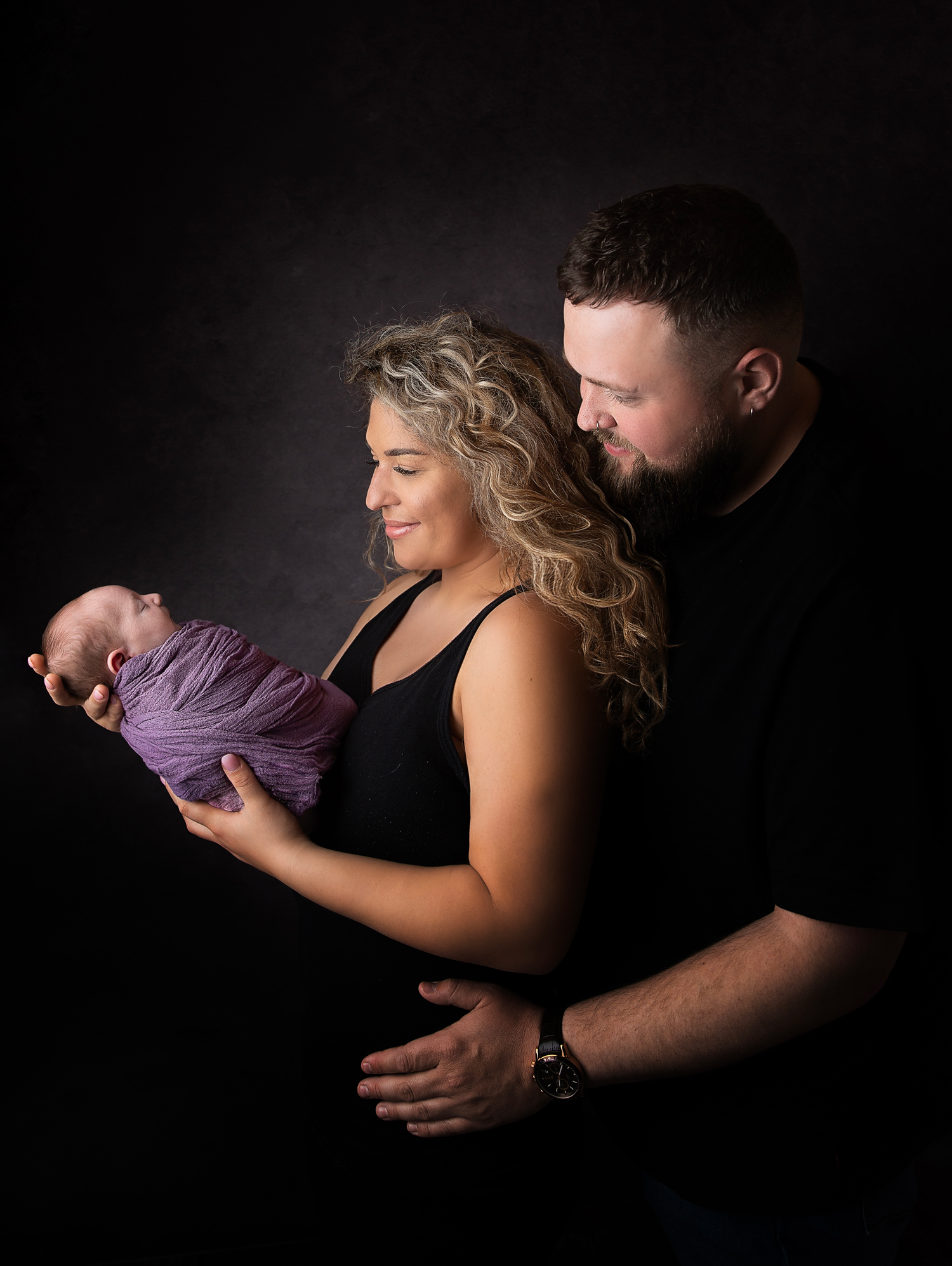 newborn and family photographer ipswich smiling new parents with baby in hands newborn and family photographer ipswich smiling new parents with baby in hands
